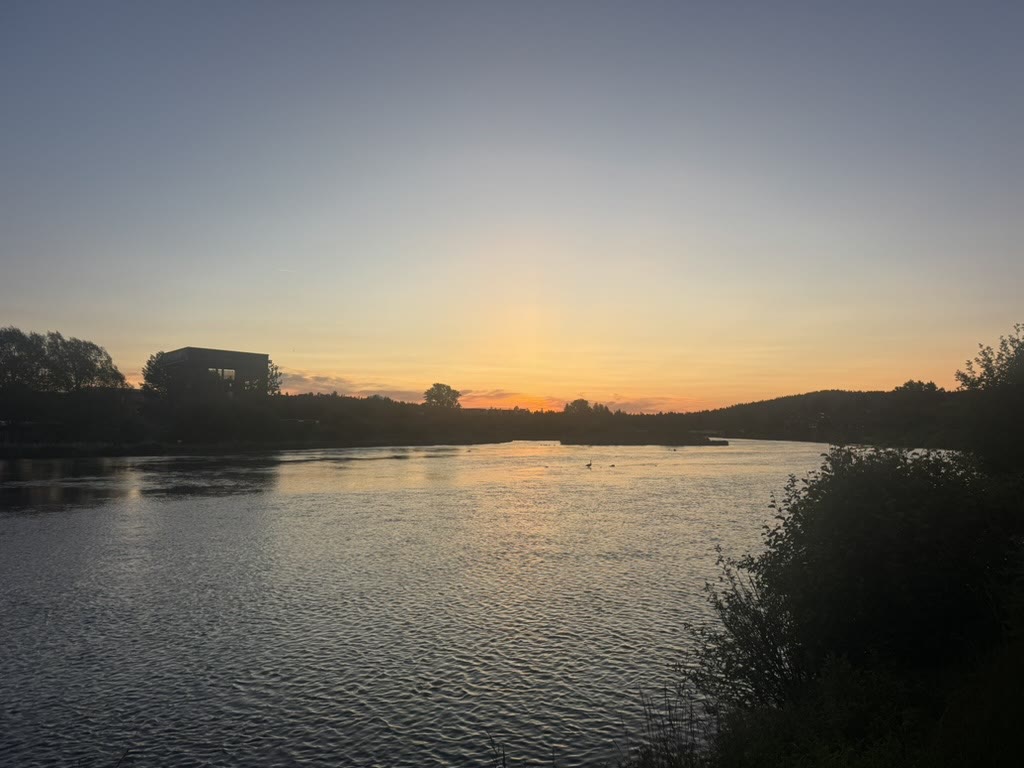 Deschutes River at golden hour, warm pink and orange sky reflected on the water