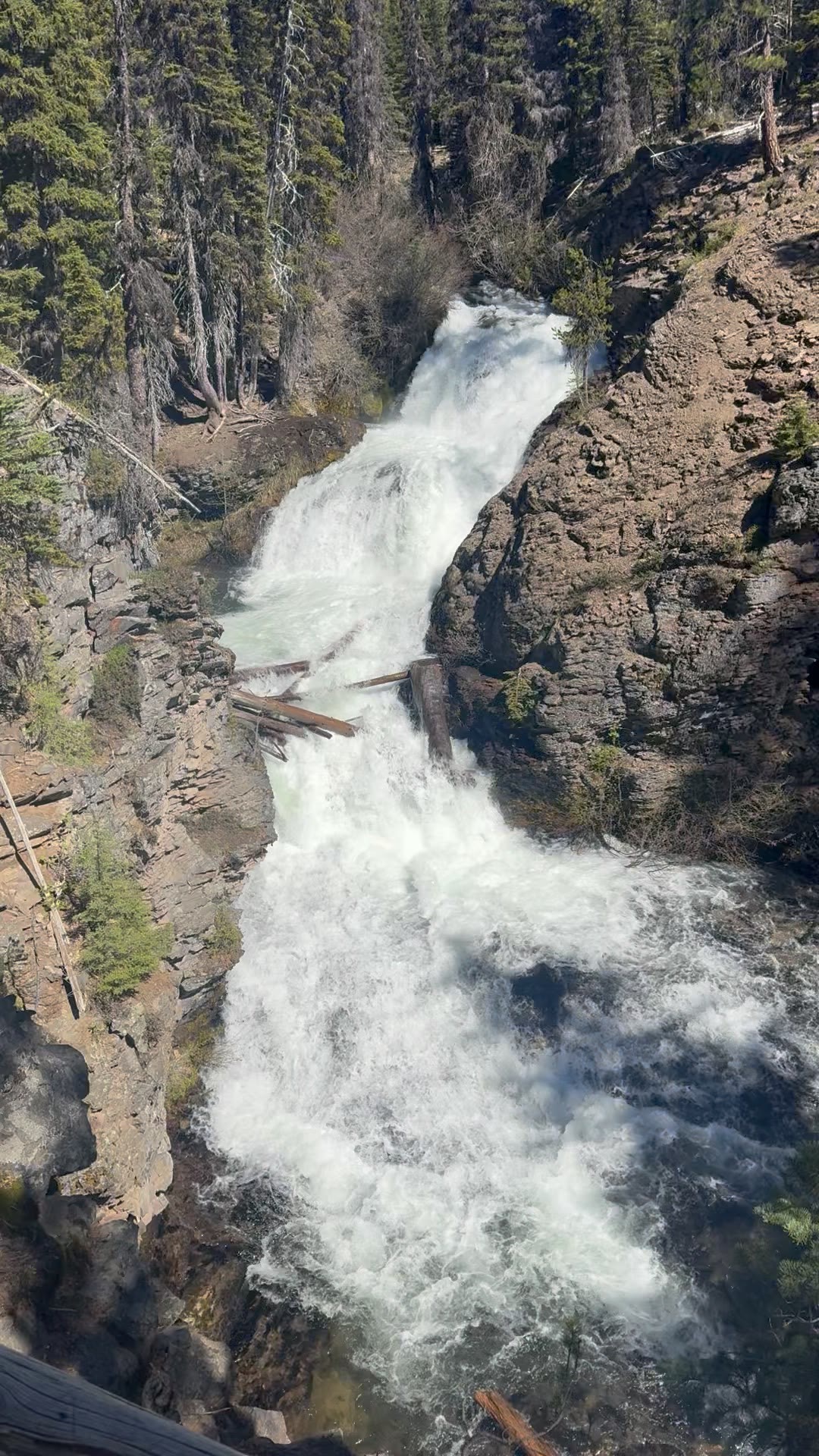Tumalo Falls in close — the lip of the drop and the spray below