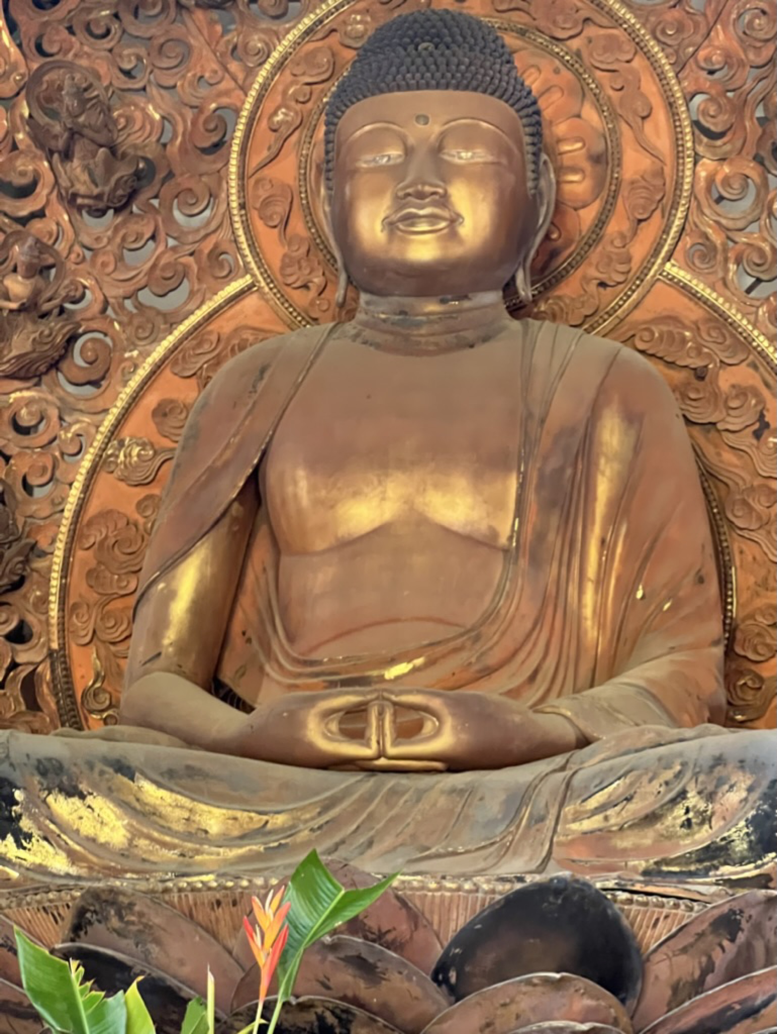The interior — a large gold Buddha statue against an ornately carved gilt wall