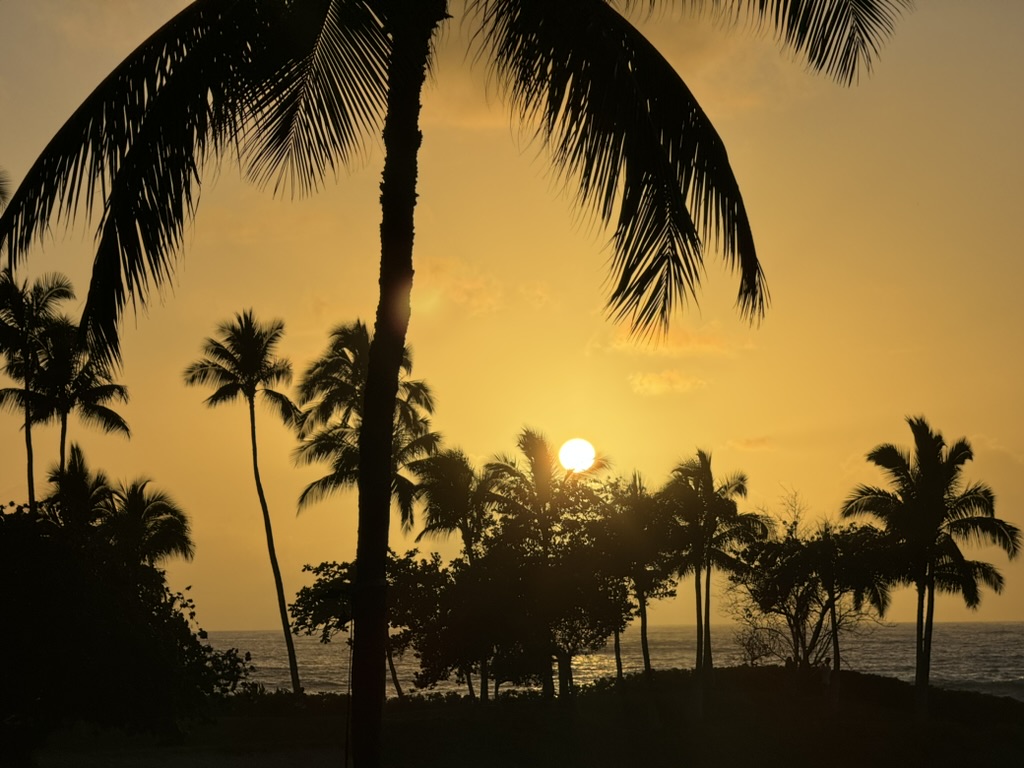 Sunset over the resort lagoon with crepuscular rays piercing through a heavy cloud deck onto the calm bay water