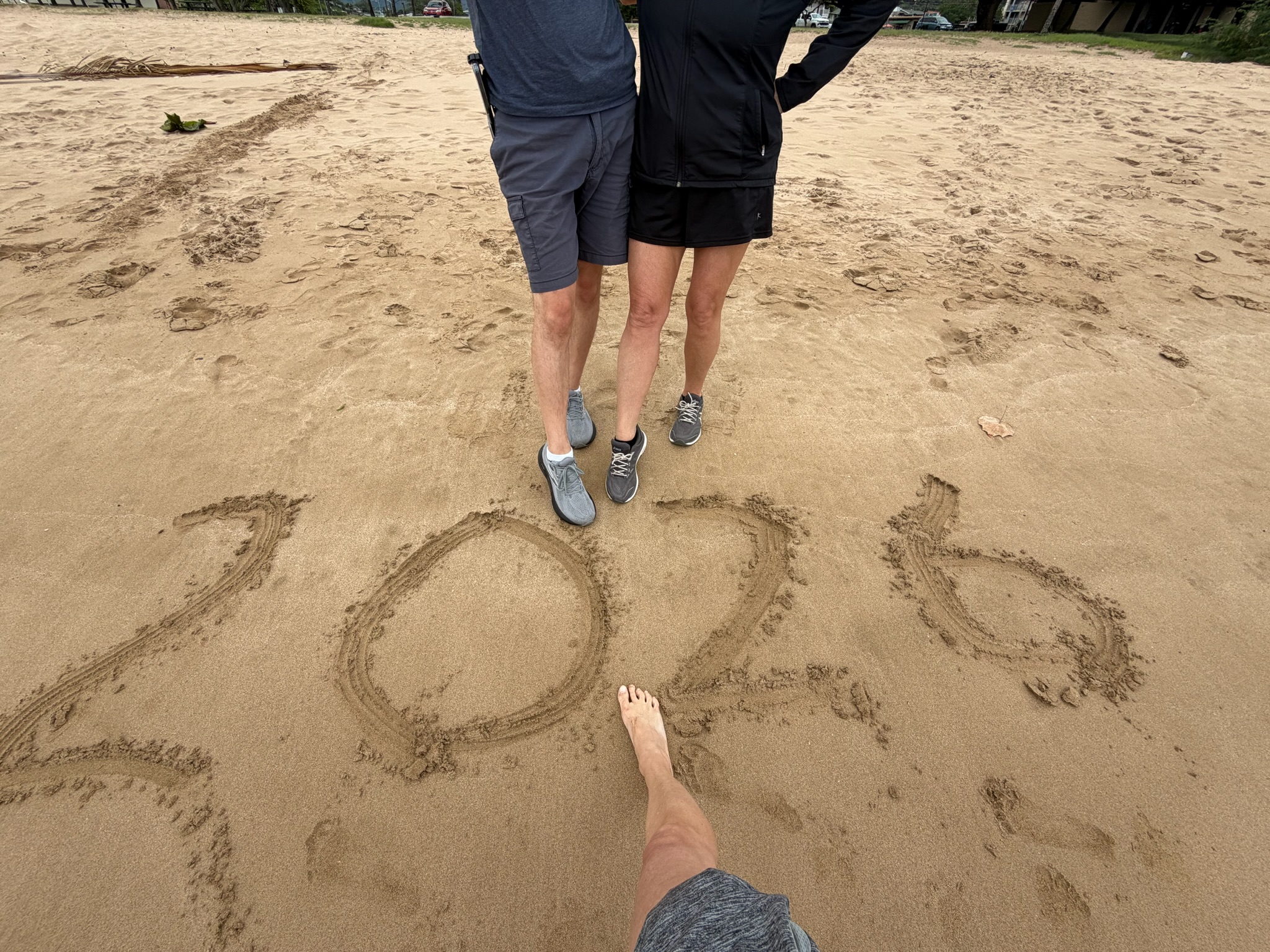 Three of us standing on a Ko Olina beach with "2026" written in the sand at our feet