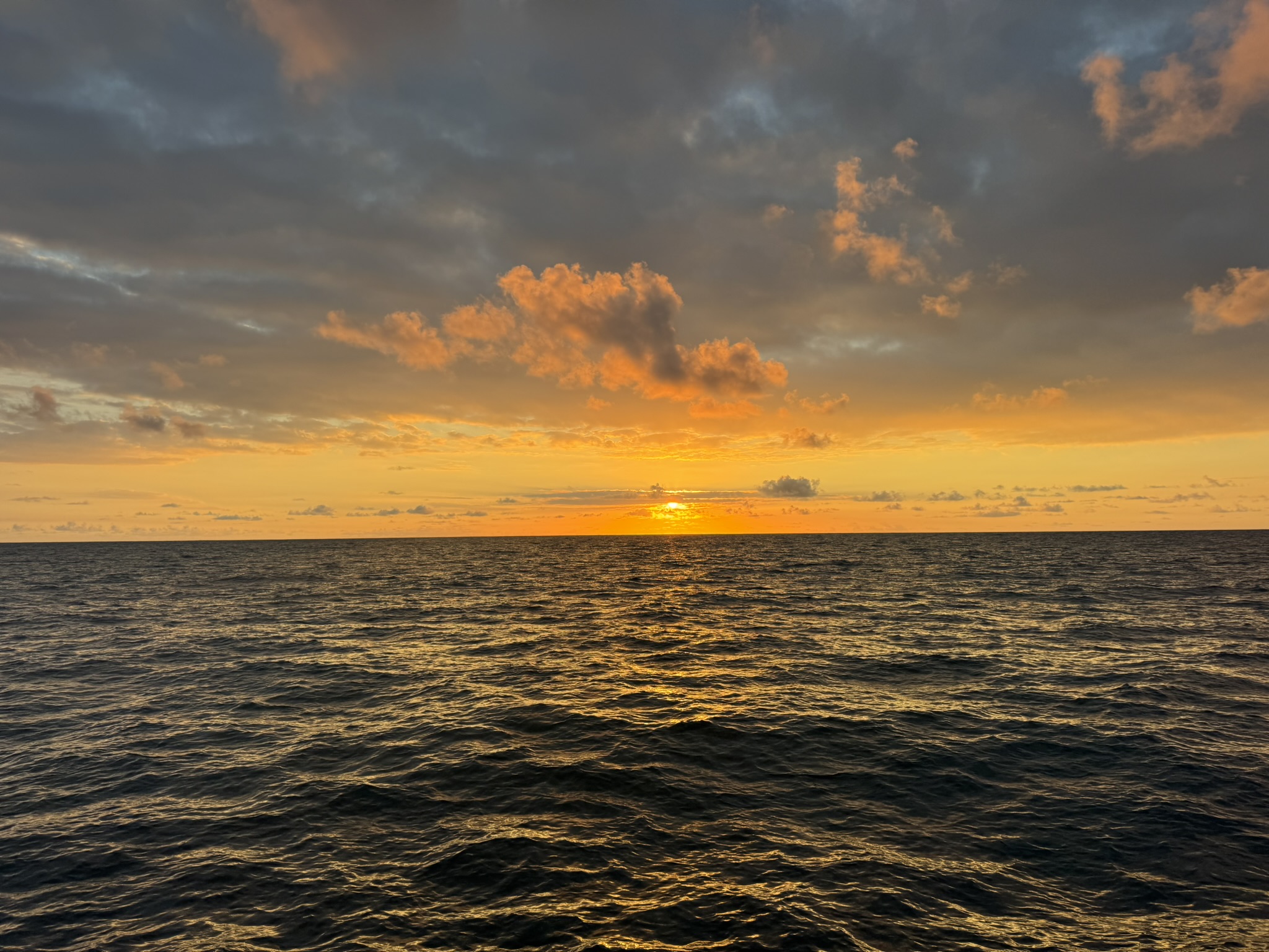 Warm sunset over the open ocean from the deck