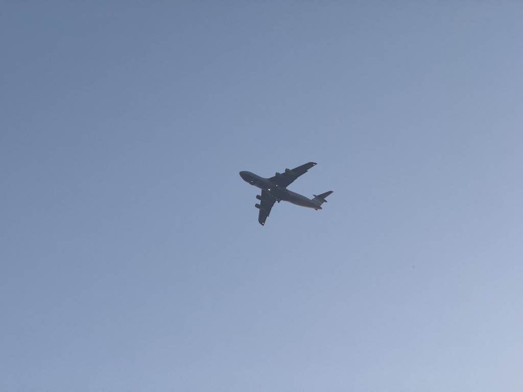 A four-engine transport jet passing overhead