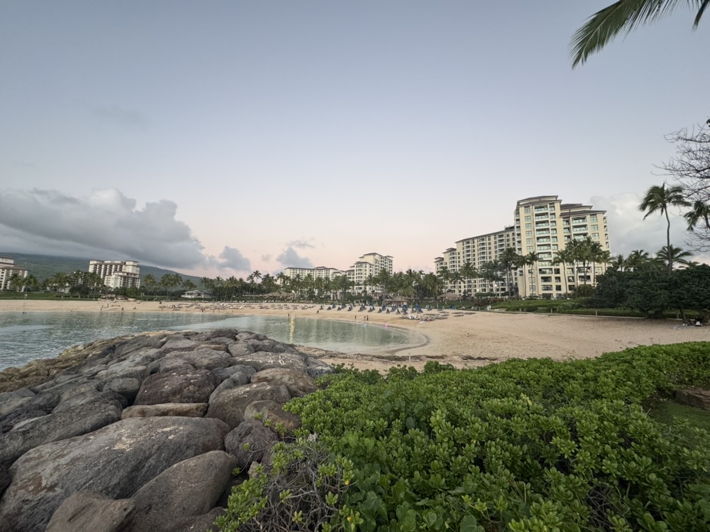 Lagoon and rocky breakwater at dusk, condos catching the last light