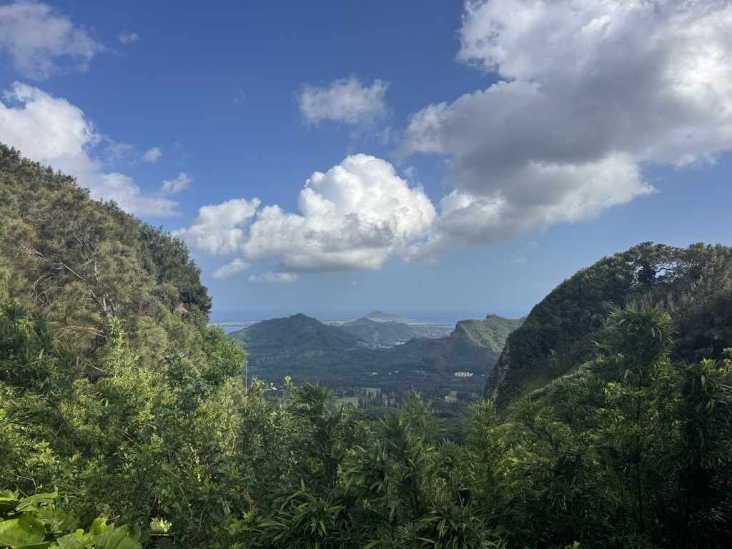 Mountain valley opening out toward a distant strip of ocean