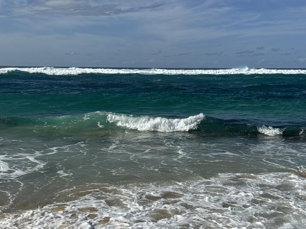 Two breaks rolling in over reef on a clear day