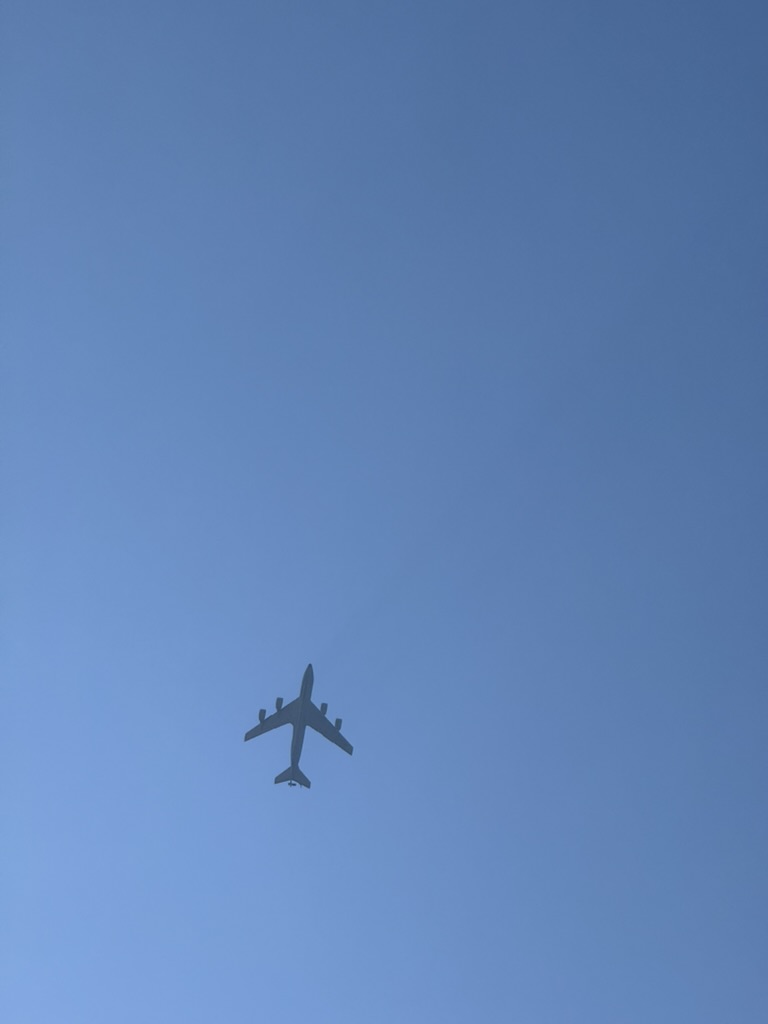 Another four-engine transport silhouetted against a hazy sky