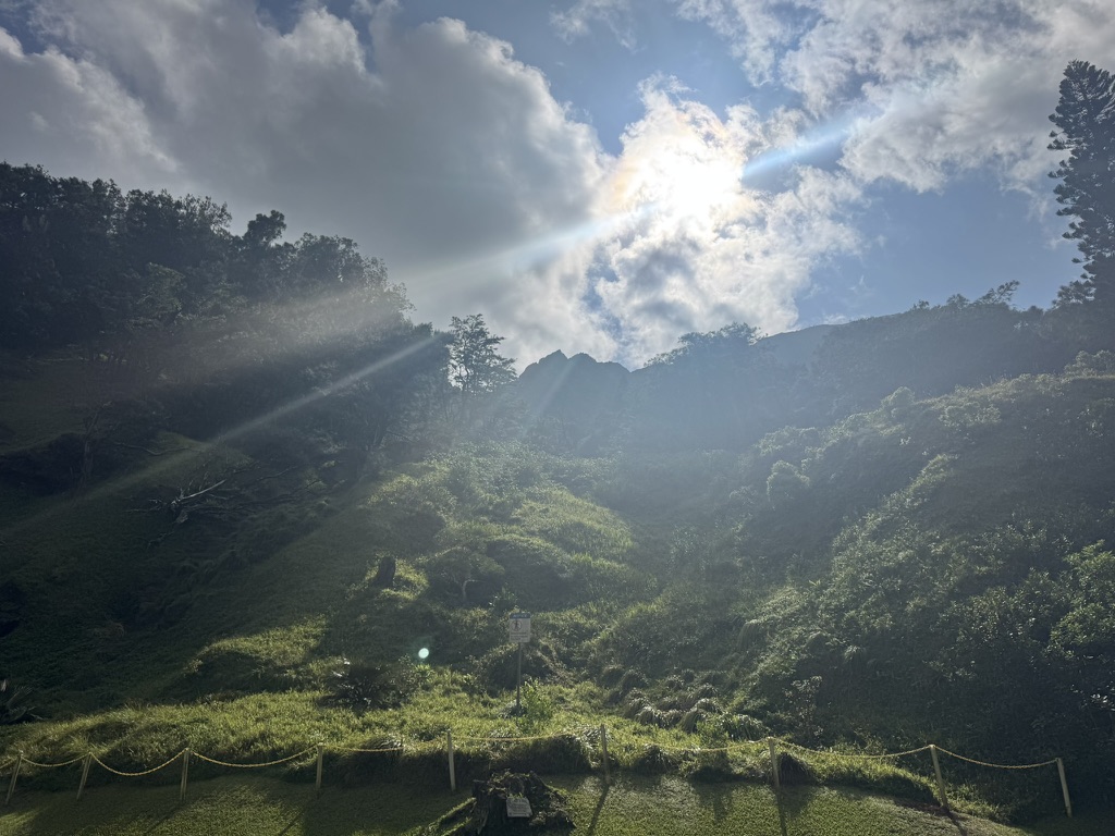 Sun beams over a green Hawaiian valley