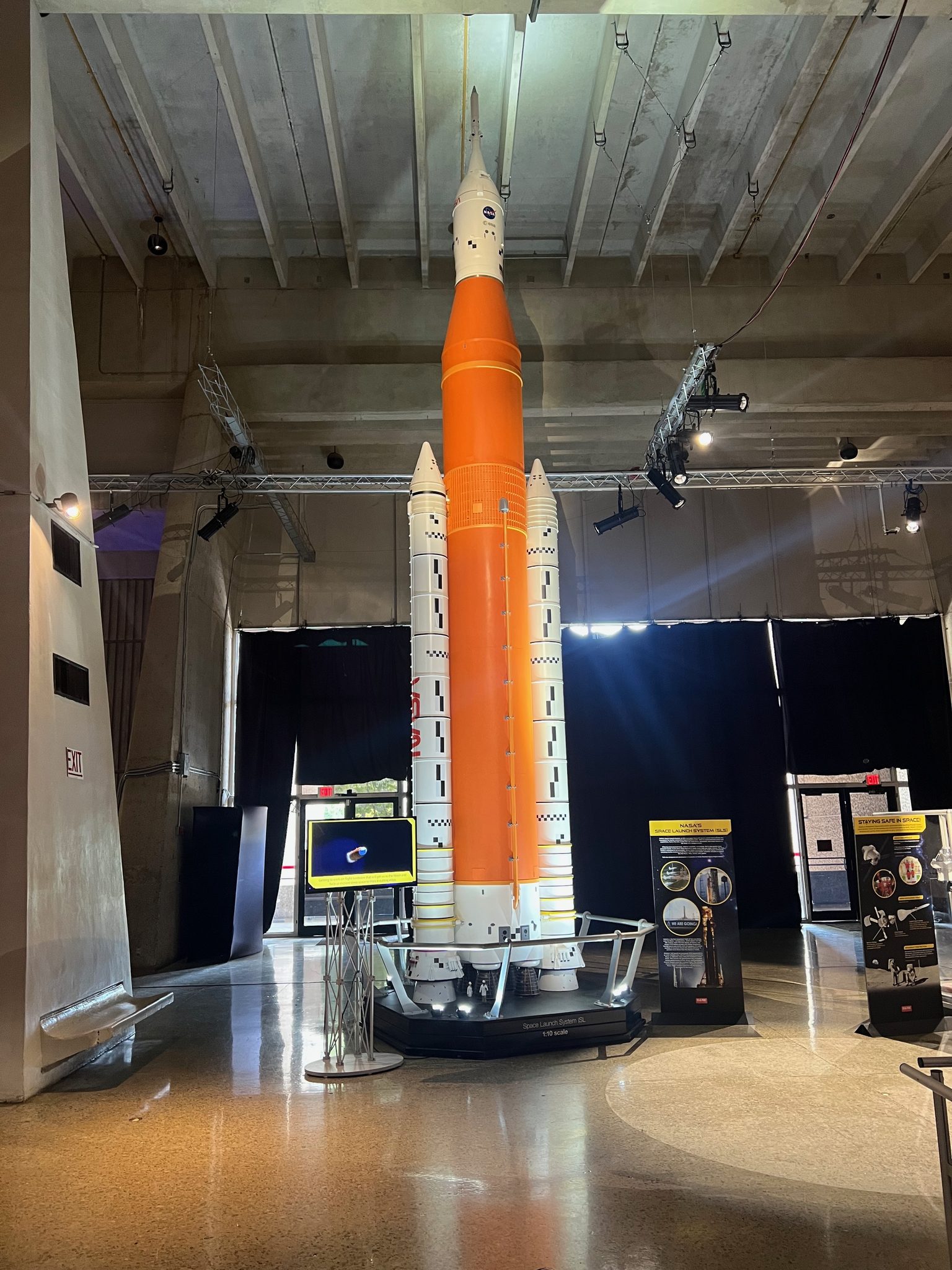 Full-scale Space Launch System model — orange core stage flanked by white solid rocket boosters — inside the Davidson Center
