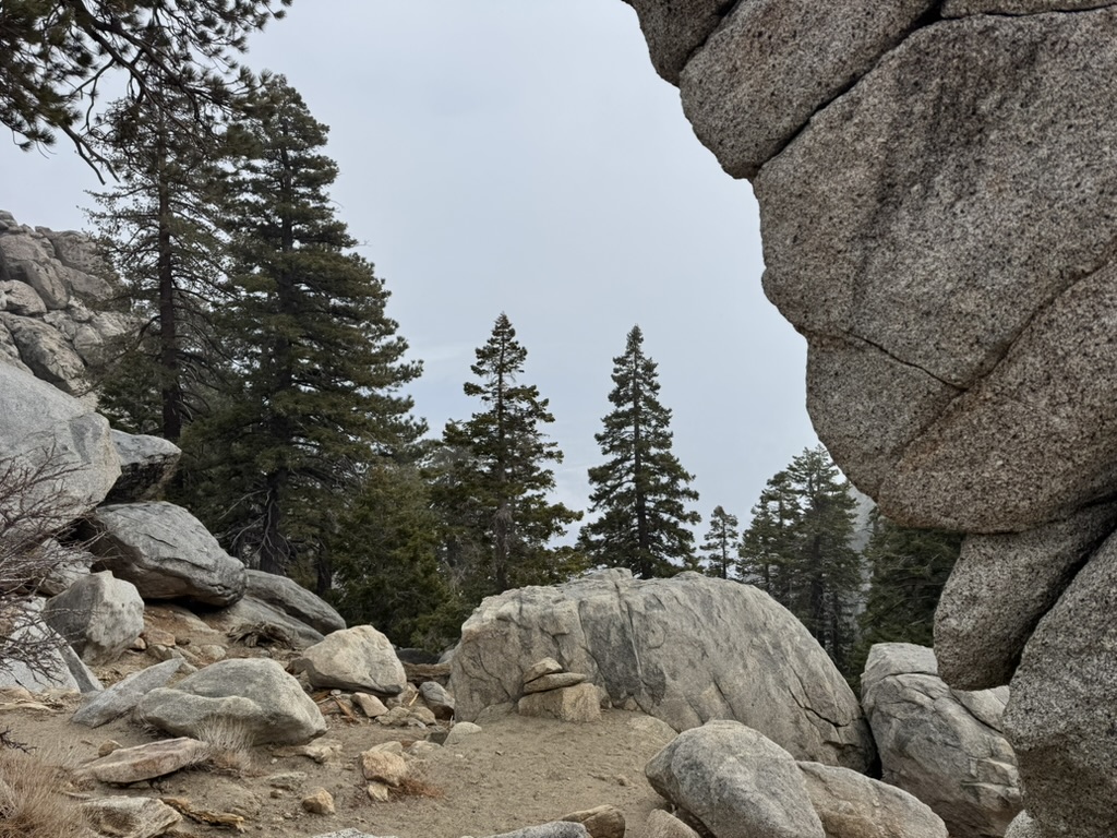 Two granite boulders forming a natural archway over the trail