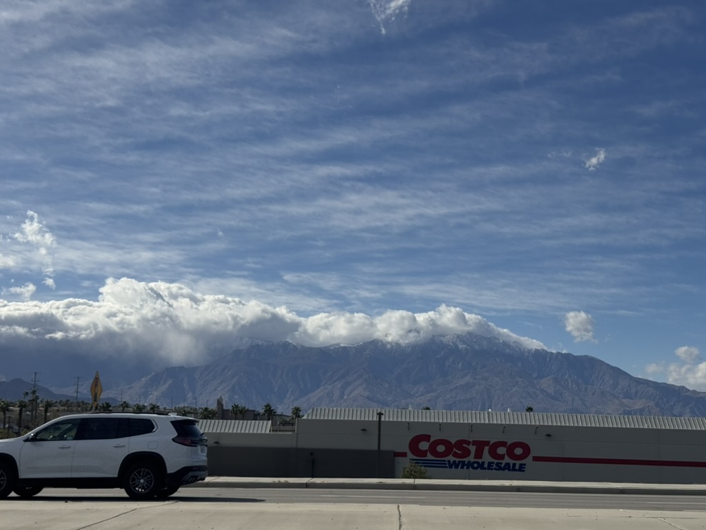 Snow-capped San Jacinto rising over a Costco store — the mountain backdrop is real even from the strip-mall
