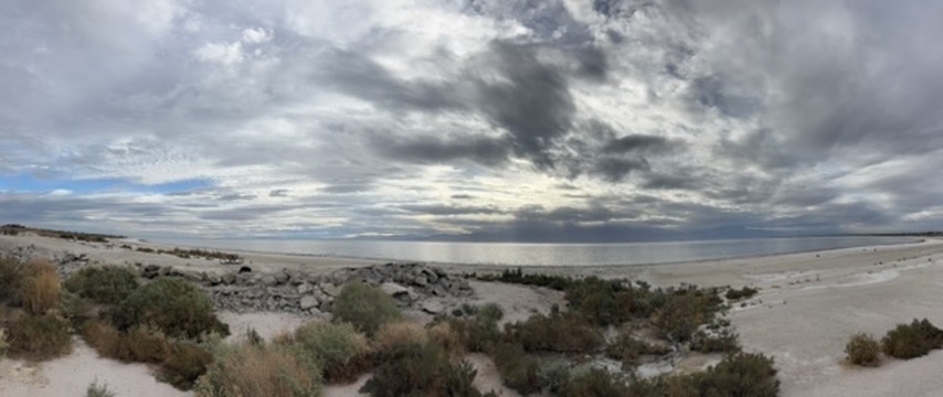 Wide panorama of the Salton Sea — flat water, distant mountains, overcast sky