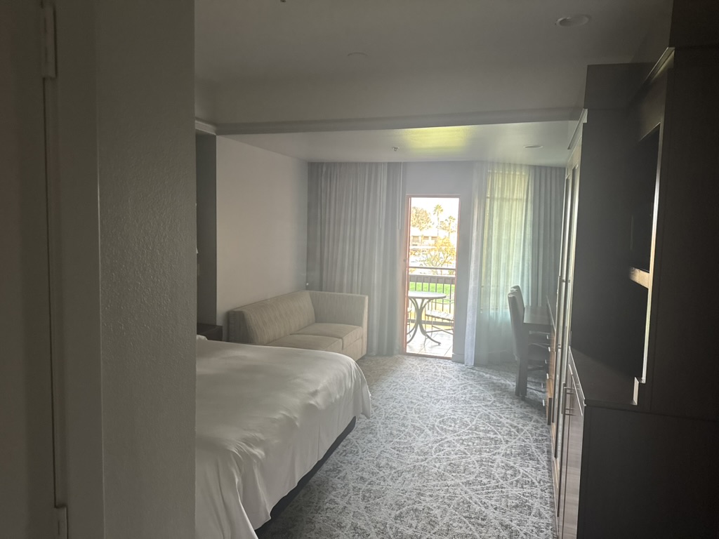 Inside the villa — bed, balcony door, the courtyard visible beyond